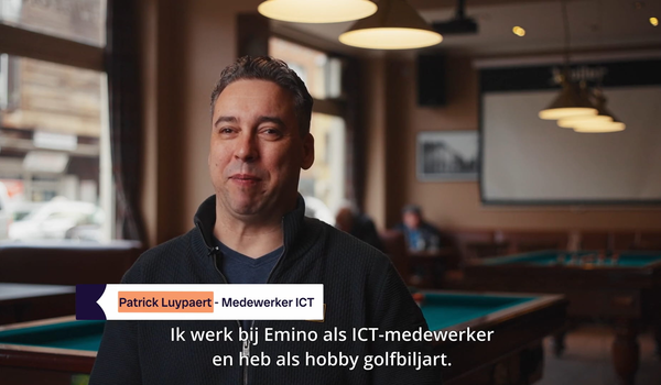 Persoon zit neer in een ruimte met biljarttafels op de achtergrond